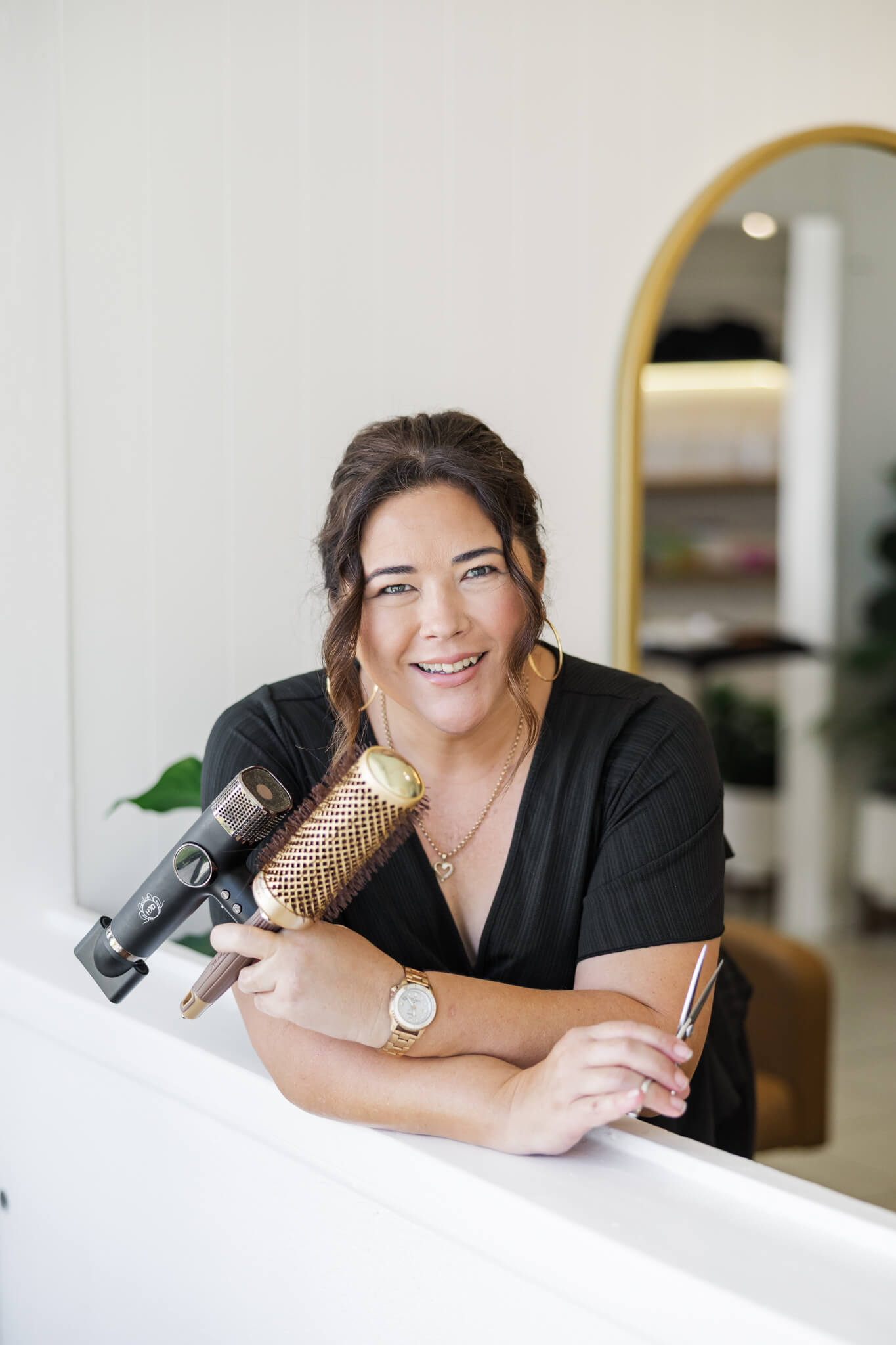 Personal branding photo of a hairdresser with her tools in her hands.